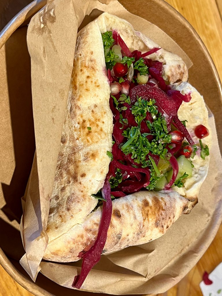Pita sabich filled with parsley leaves and red beet